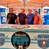 Belleville Oktoberfest festival vendors pose for photo in booth on Main Street.