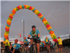 Many bike riders start the Tour de Belleville under a balloon archway